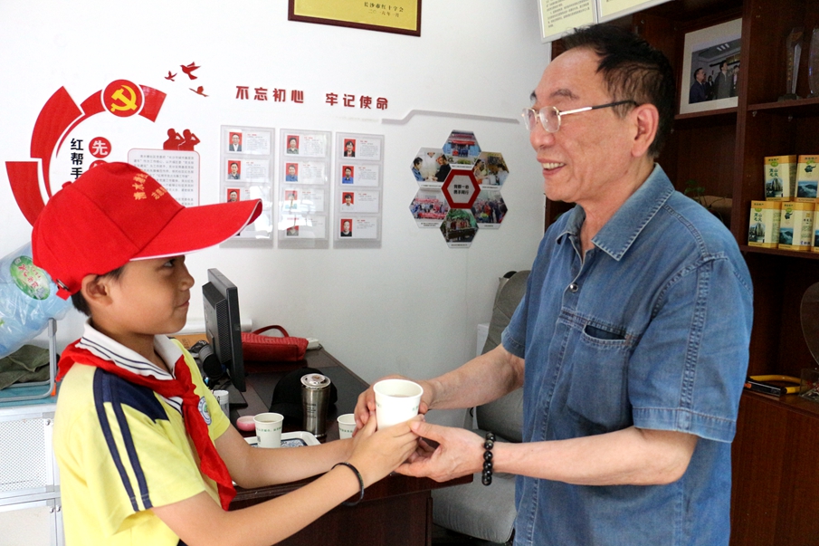 戴上小红帽，我就是小小志愿者！在第三个活动实践点，朱彬锋将做两个小时的志愿服务体验志愿者的工作内容。朱彬锋为服务站内的老年朋友们倒茶。