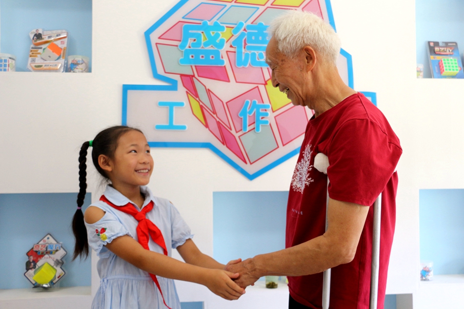 7月29日，来自四方坪小学的张译丹在丝茅冲社区盛德其工作室见到了“中国好人”盛德其。两人一见面便亲切地握手。